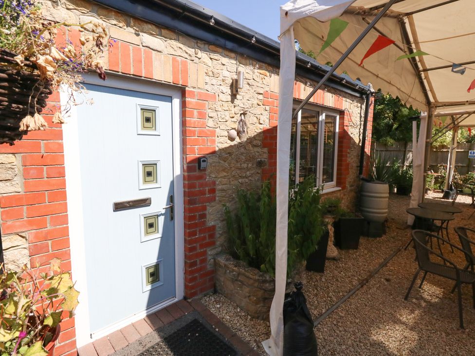 An entrance with a front door and outdoor seating area at The Old Barn in Stourton Caundle near Stalbridge