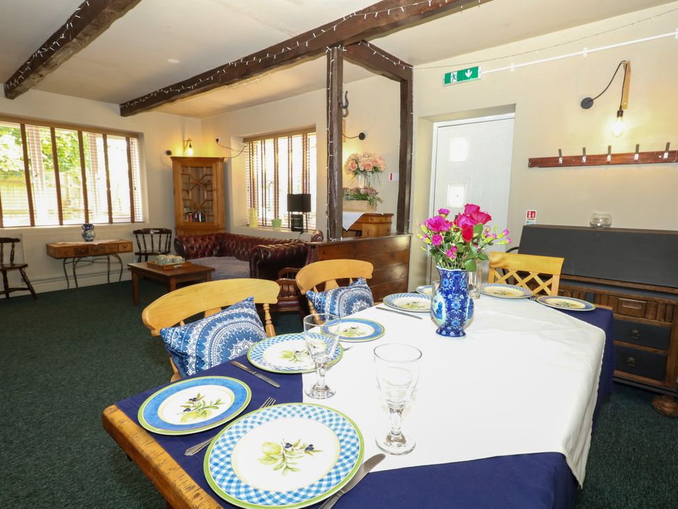 A dining room with a table set for meals at The Old Barn in Stourton Caundle near Stalbridge
