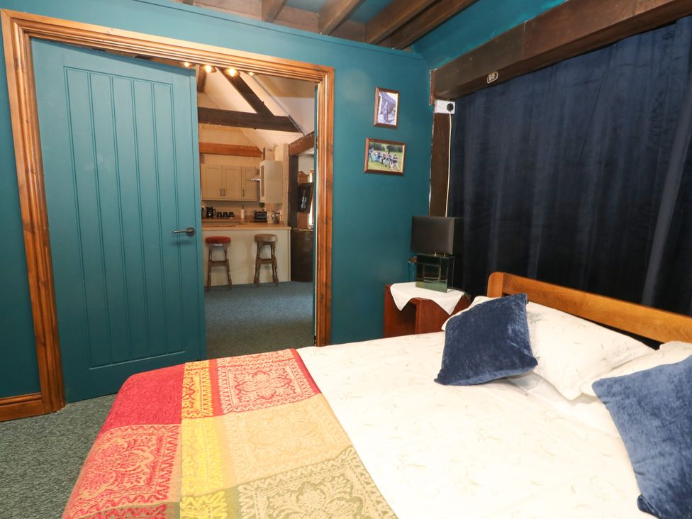 A bedroom with a bed and door at The Old Barn in Stourton Caundle near Stalbridge
