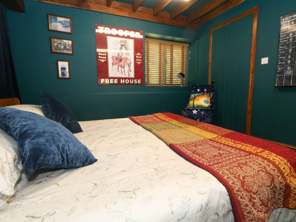 A bedroom with a bed and decorative items at The Old Barn in Stourton Caundle near Stalbridge