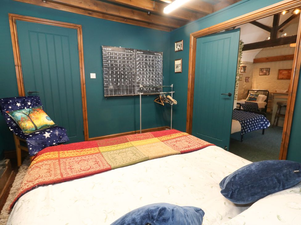 A bedroom with a bed and calendar at The Old Barn in Stourton Caundle near Stalbridge