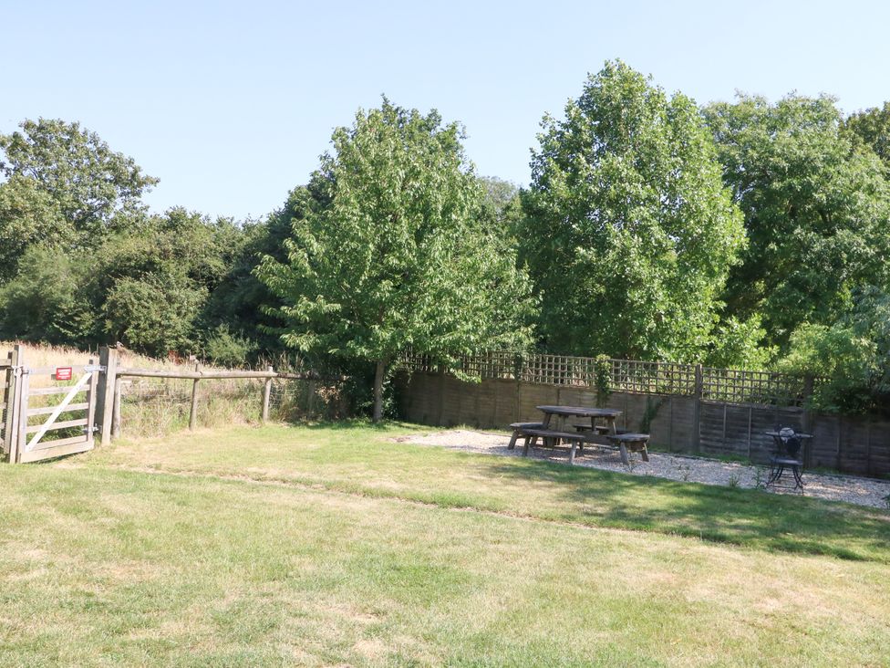 A garden with a picnic table and trees at The Old Barn in Stourton Caundle near Stalbridge
