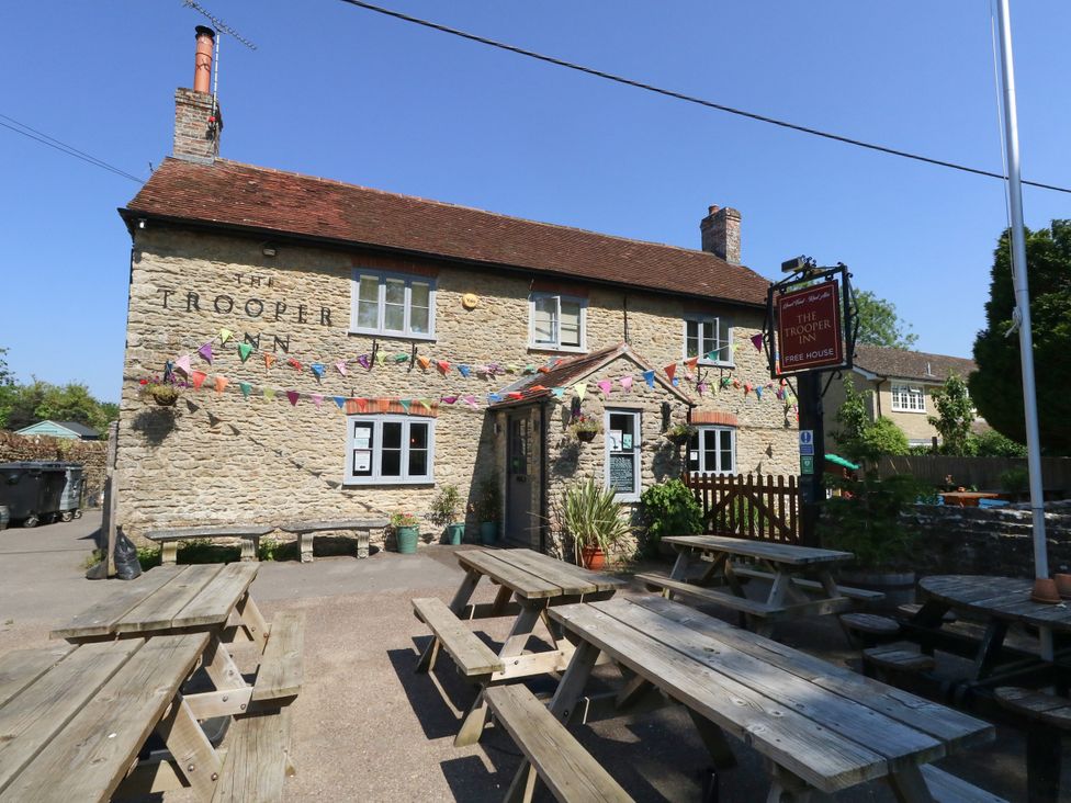 A pub with outdoor seating and bunting at The Old Barn in Stourton Caundle near Stalbridge