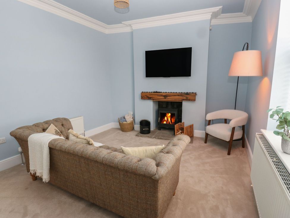 A living room with a sofa and fireplace at 11 Bronte Street in Haworth