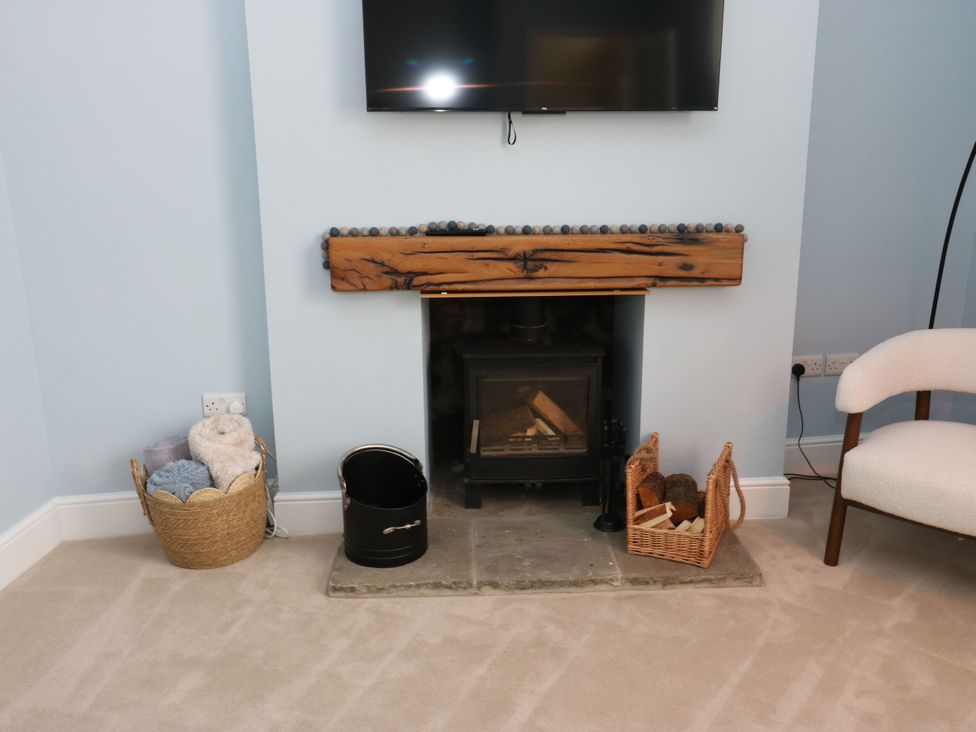A living room with a fireplace and television at 11 Bronte Street in Haworth