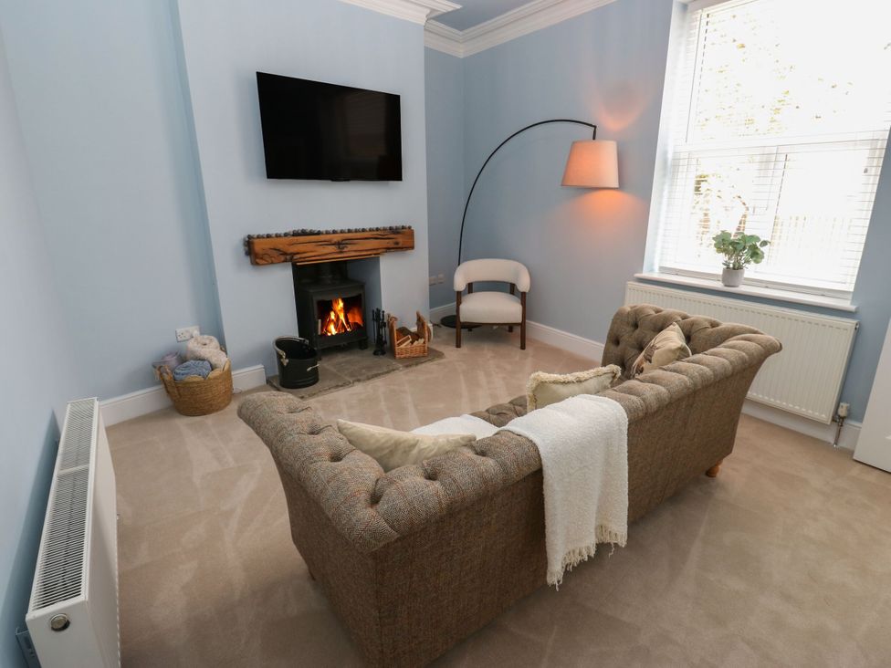 A living room with a sofa and fireplace at 11 Bronte Street, Haworth