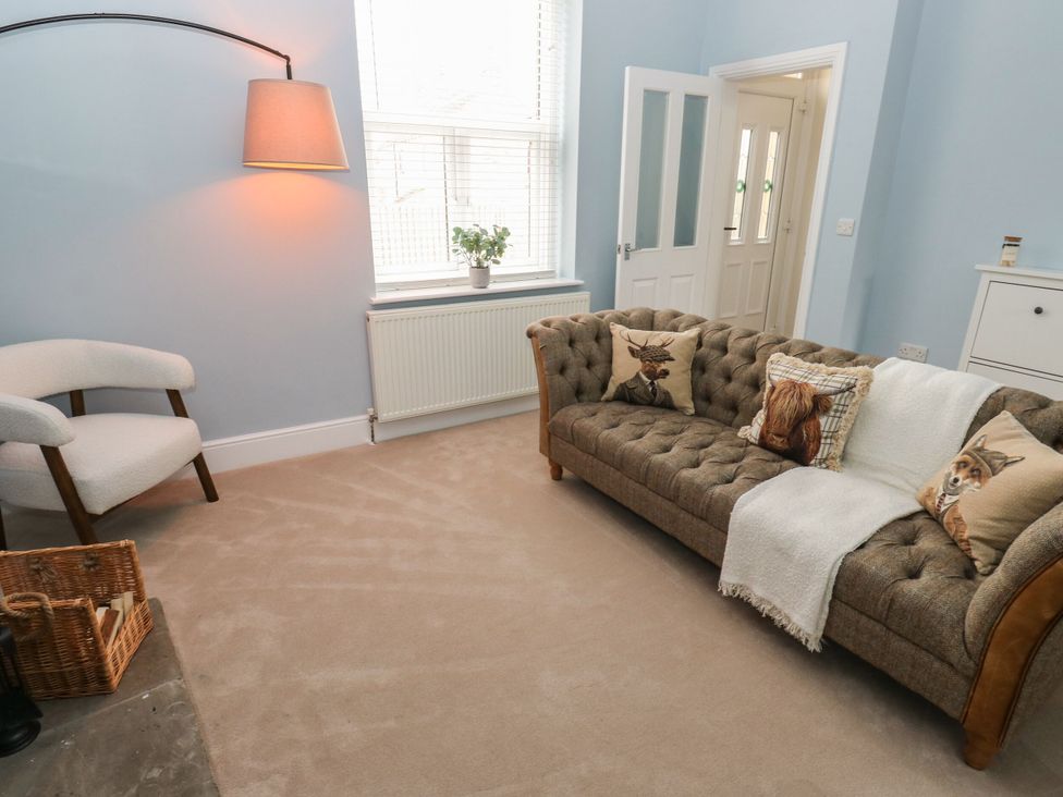 A living room with a sofa and chair at 11 Bronte Street in Haworth