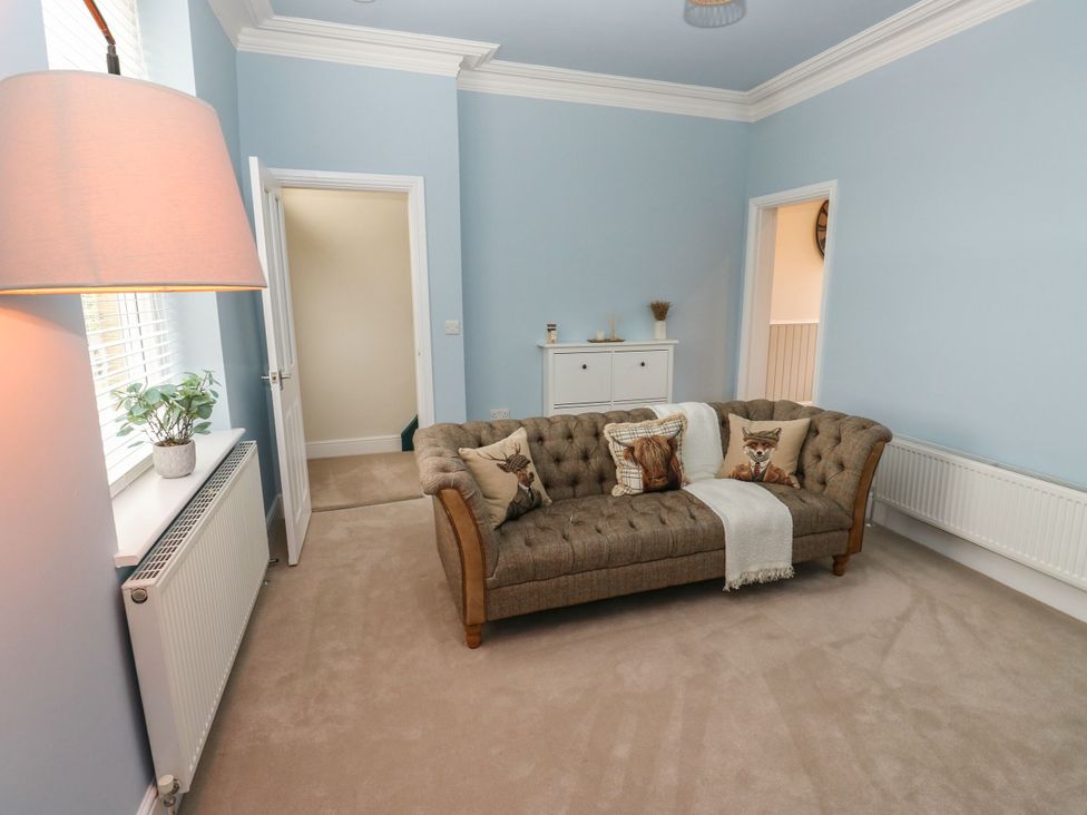 A living room with a sofa and side table at 11 Bronte Street in Haworth
