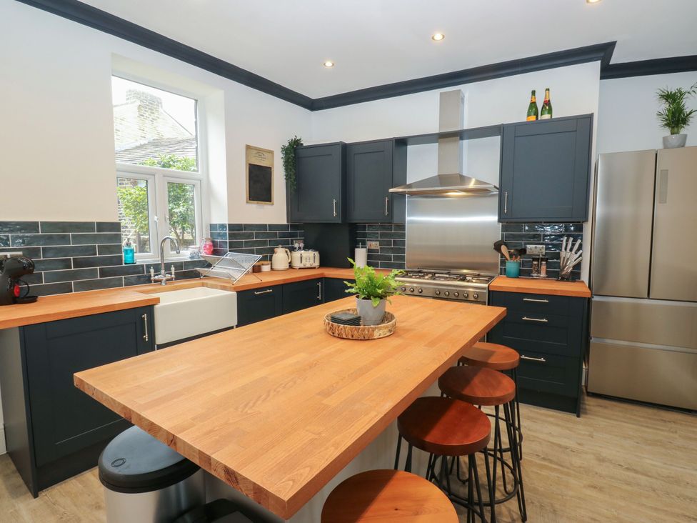 A kitchen with a cooking range and sink at 11 Bronte Street in Haworth