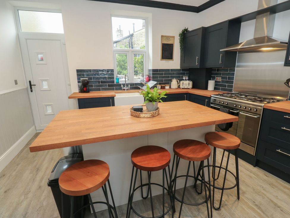 A kitchen with an island and stools at 11 Bronte Street Haworth