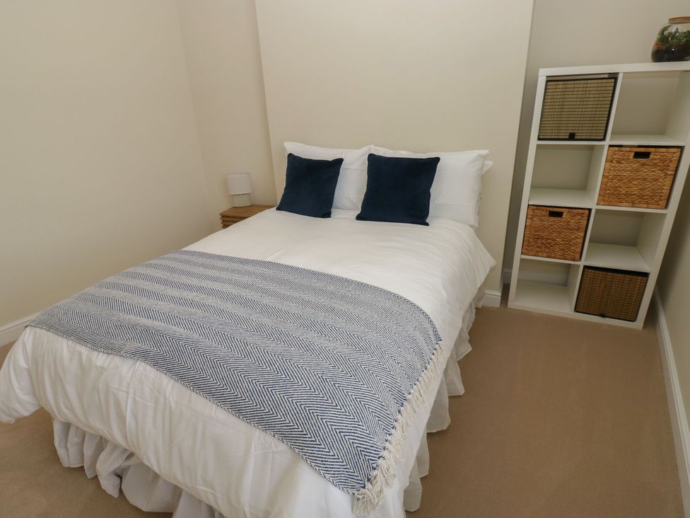 A bedroom with a bed and storage shelves at 11 Bronte Street in Haworth