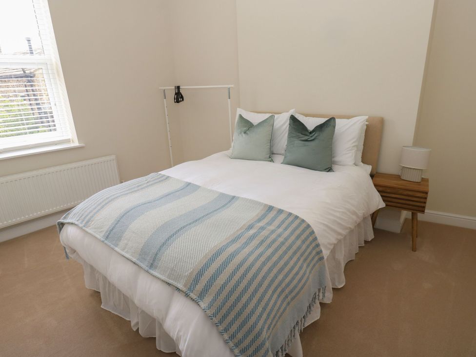 A bedroom with a bed and cushions at 11 Bronte Street Haworth