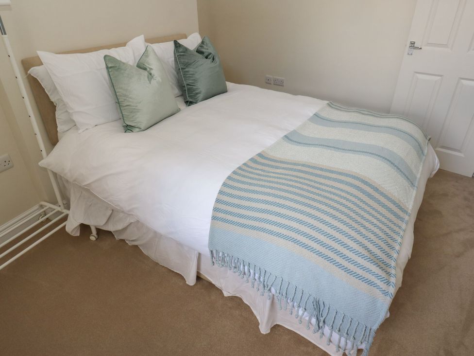A bed with pillows and a blanket at 11 Bronte Street in Haworth
