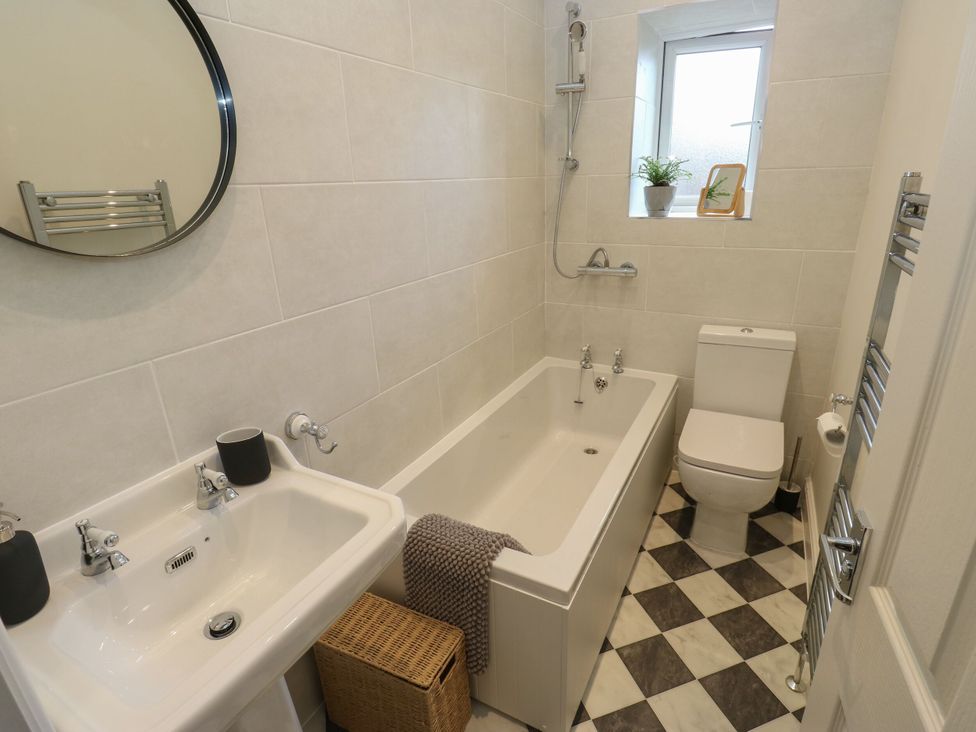 A bathroom with a bath tub and sink at 11 Bronte Street in Haworth