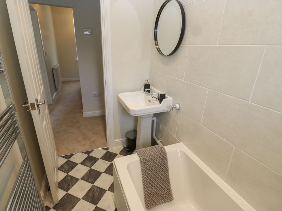 A bathroom with a sink, bath, and towel at 11 Bronte Street in Haworth