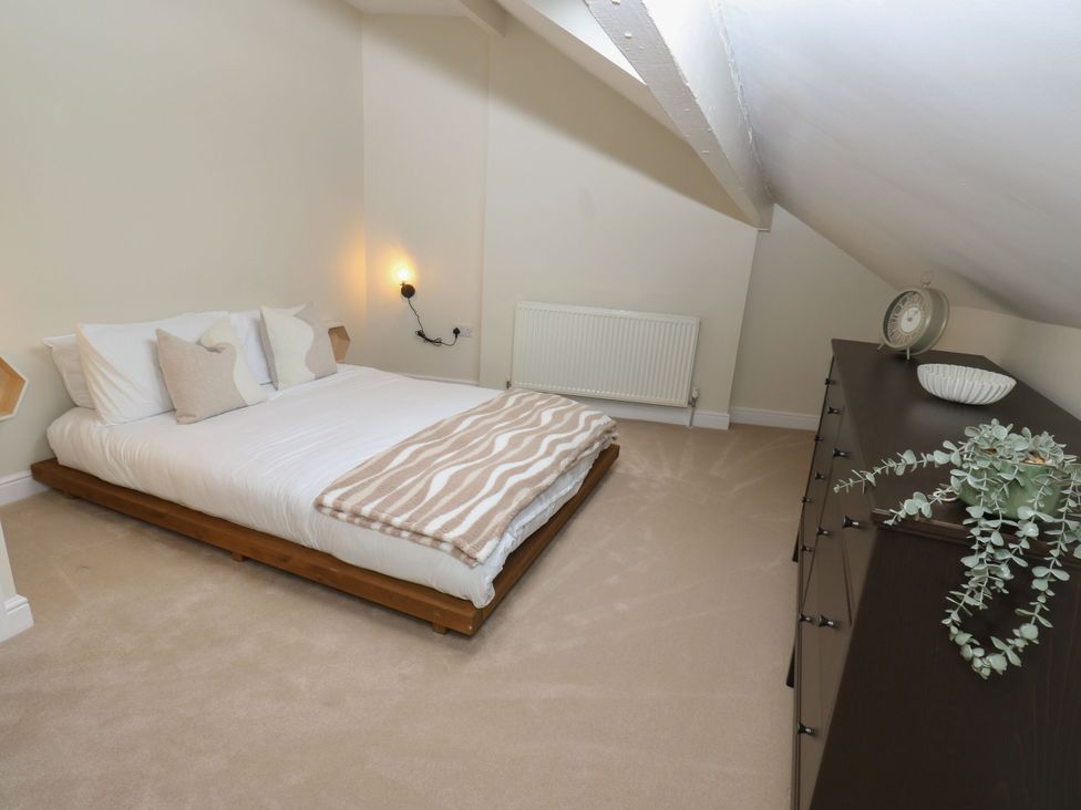 A bedroom with a bed and dresser at 11 Bronte Street in Haworth