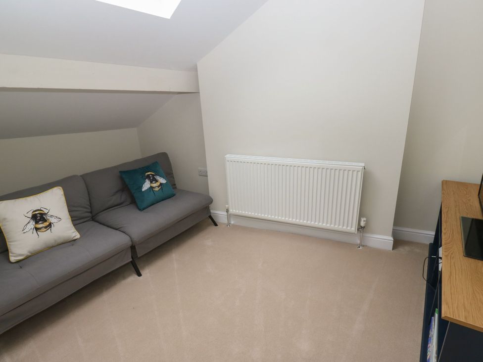 A snug with a sofa and a radiator at 11 Bronte Street in Haworth