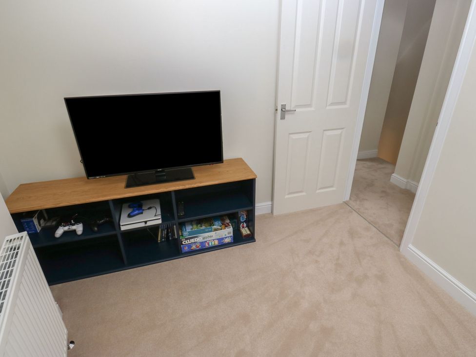 A snug with a television and shelves at 11 Bronte Street in Haworth