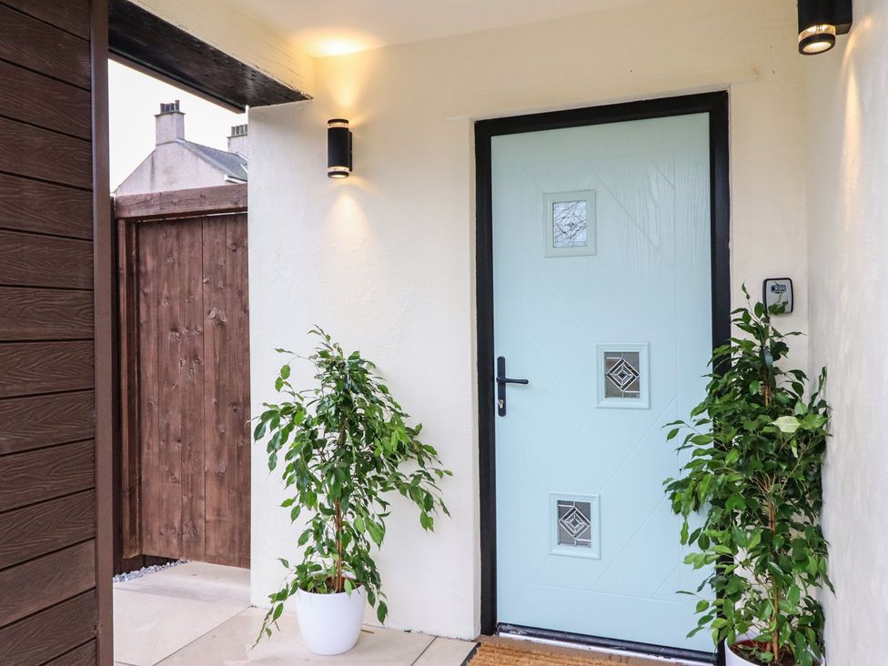 An entrance area with a blue door and plants at Pistyll Ddu in Brynsiencyn near Llanfairpwllgwyngyll