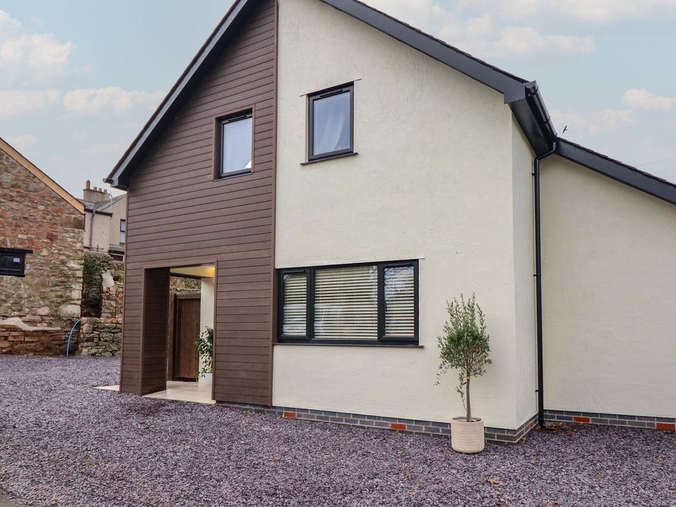 An exterior view of a house with gravel and a plant at Pistyll Ddu in Brynsiencyn near Llanfairpwllgwyngyll