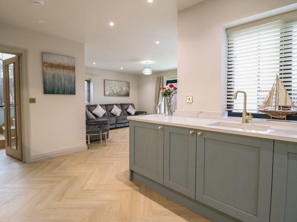 A kitchen with a kitchen island and a sofa at Pistyll Ddu in Brynsiencyn near Llanfairpwllgwyngyll