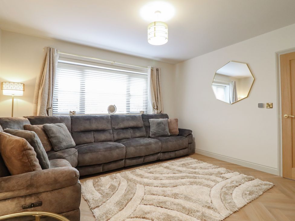 A living room with a sofa and lamp at Pistyll Ddu Brynsiencyn near Llanfairpwllgwyngyll