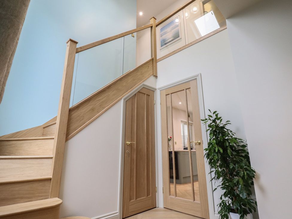 A hallway with a staircase and door at Pistyll Ddu in Brynsiencyn near Llanfairpwllgwyngyll