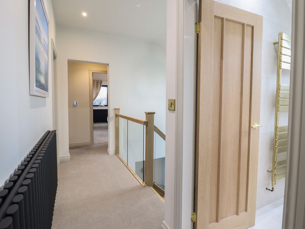 A hallway with doors and a staircase at Pistyll Ddu in Brynsiencyn near Llanfairpwllgwyngyll