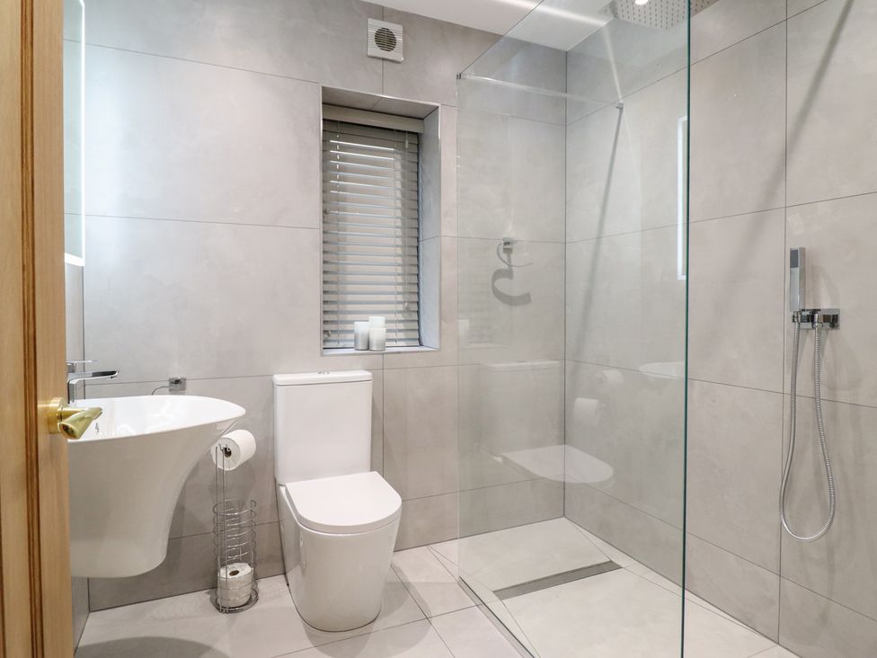 A bathroom with a shower and toilet at Pistyll Ddu near Brynsiencyn
