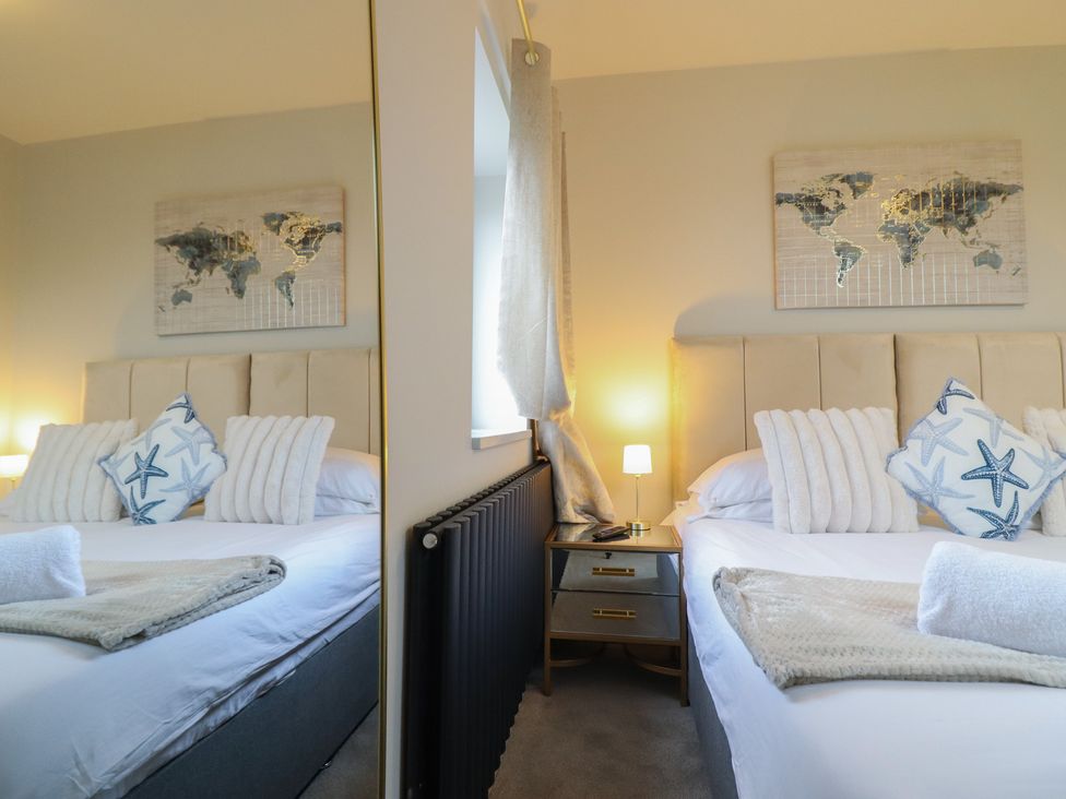 A bedroom with a bed and decorative pillows at Pistyll Ddu near Brynsiencyn near Llanfairpwllgwyngyll