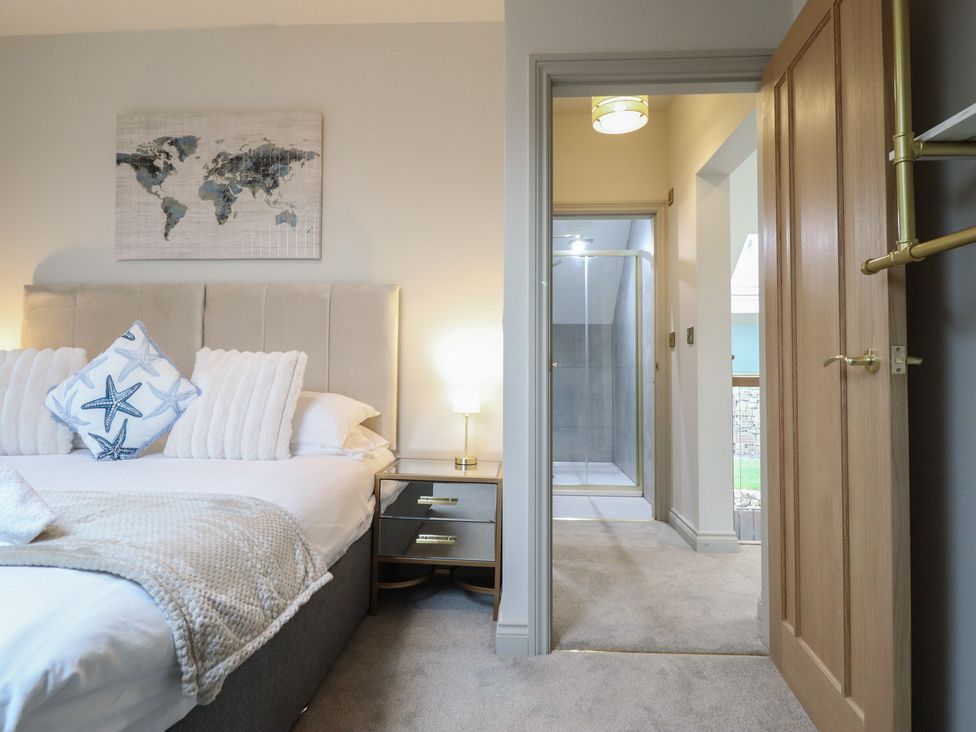 A bedroom with a bed and ensuite shower at Pistyll Ddu in Brynsiencyn near Llanfairpwllgwyngyll