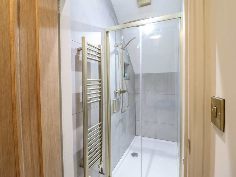 A shower with a towel warmer in a bathroom at Pistyll Ddu in Brynsiencyn near Llanfairpwllgwyngyll