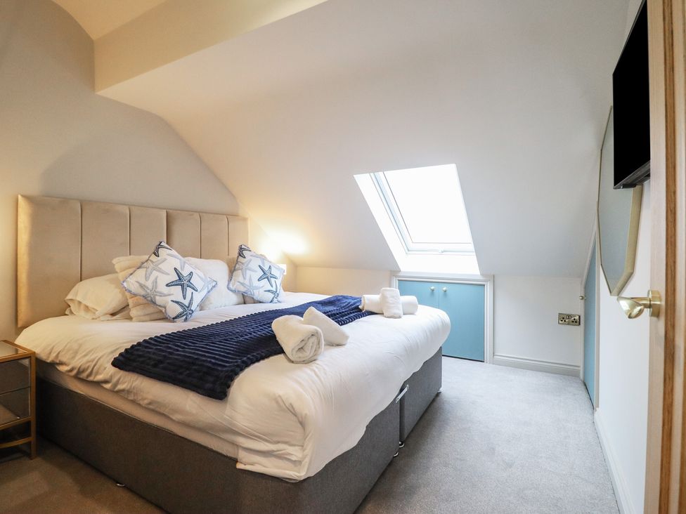 A bedroom with a bed and window at Pistyll Ddu Brynsiencyn near Llanfairpwllgwyngyll