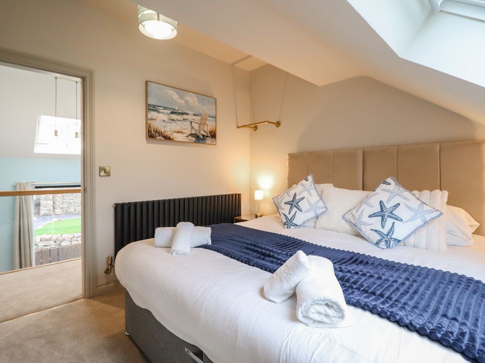 A bedroom with a large bed and a painting at Pistyll Ddu in Brynsiencyn near Llanfairpwllgwyngyll