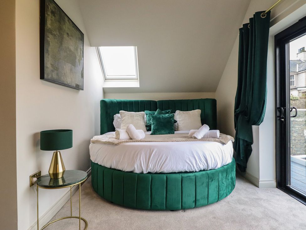 A bedroom with a round bed and a green lamp at Pistyll Ddu in Brynsiencyn near Llanfairpwllgwyngyll