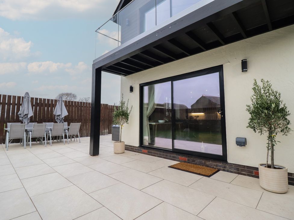 An outdoor patio with table and chairs at Pistyll Ddu in Brynsiencyn near Llanfairpwllgwyngyll