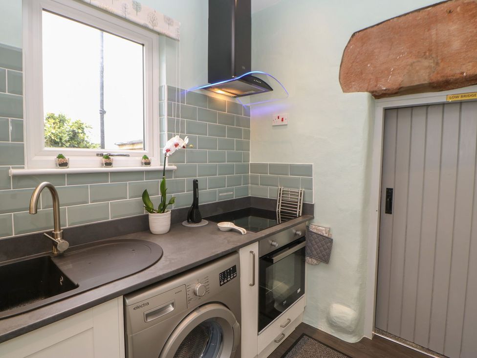A kitchen with a washing machine and oven at Orchard Cottage in Appleby-in-Westmorland