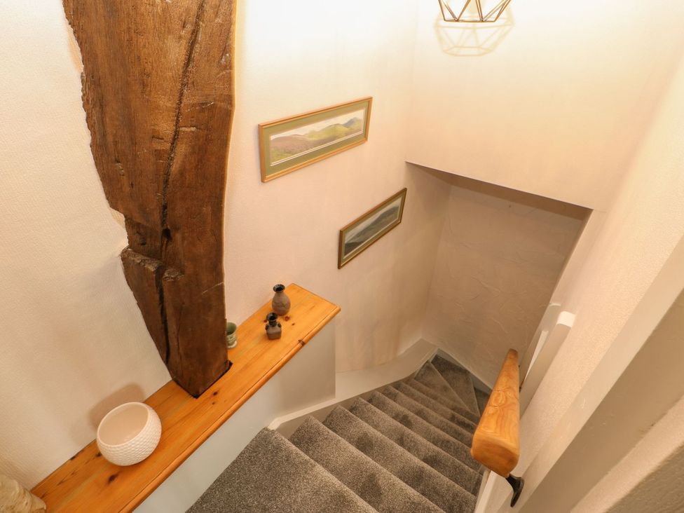 A stairway with wooden features and decorative items at Orchard Cottage in Appleby-in-Westmorland