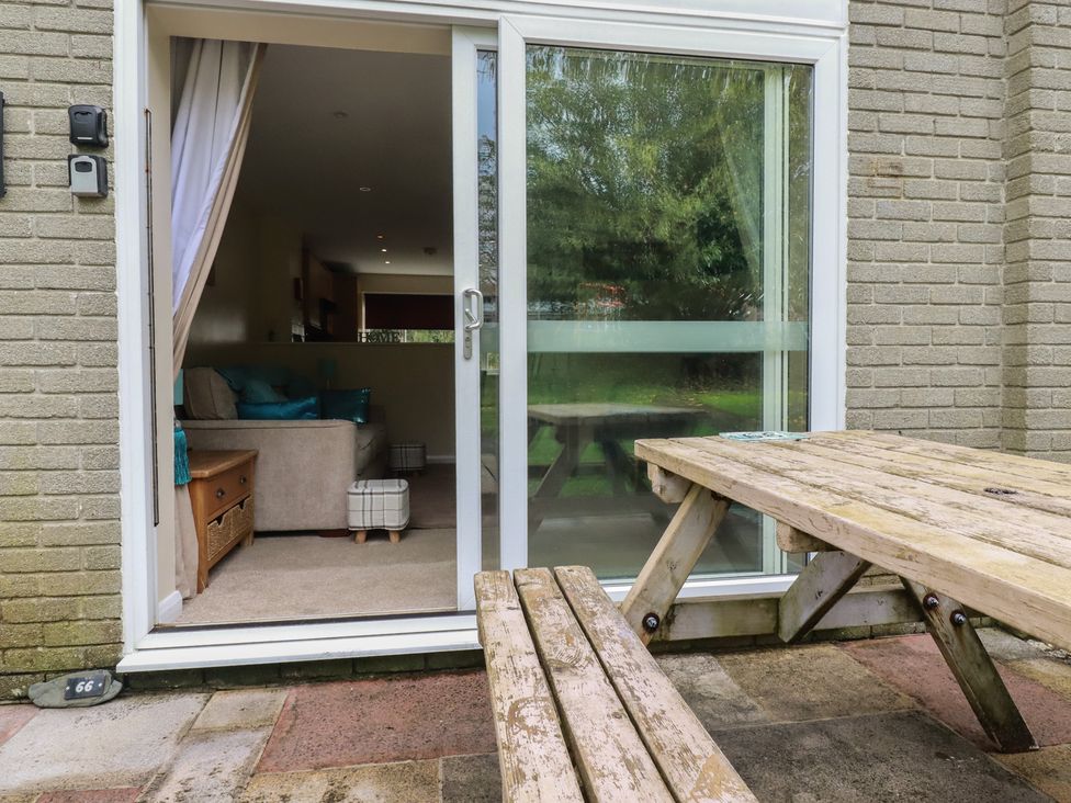 An outdoor seating area with a table and chairs at Poolside, Atlantic Reach resort, near St Columb Major