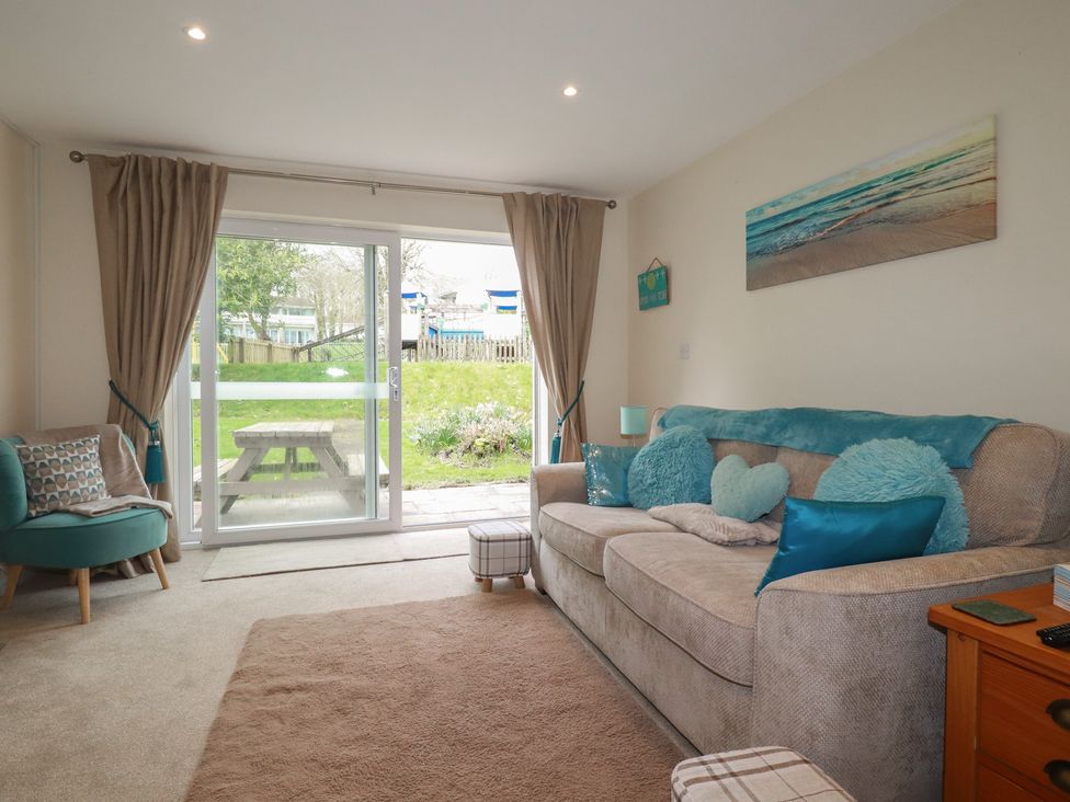 A living room with sofa and table at Poolside, Atlantic Reach resort, near St Columb Major