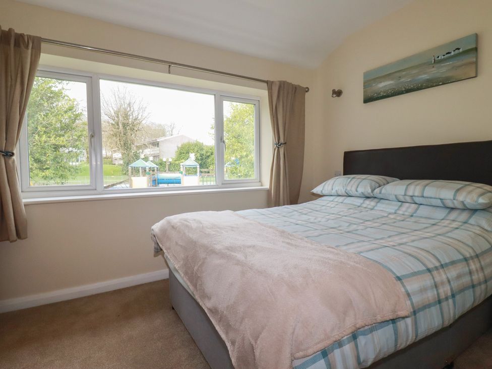 A bedroom with a bed and a window at Poolside in Atlantic Reach resort, near St Columb Major