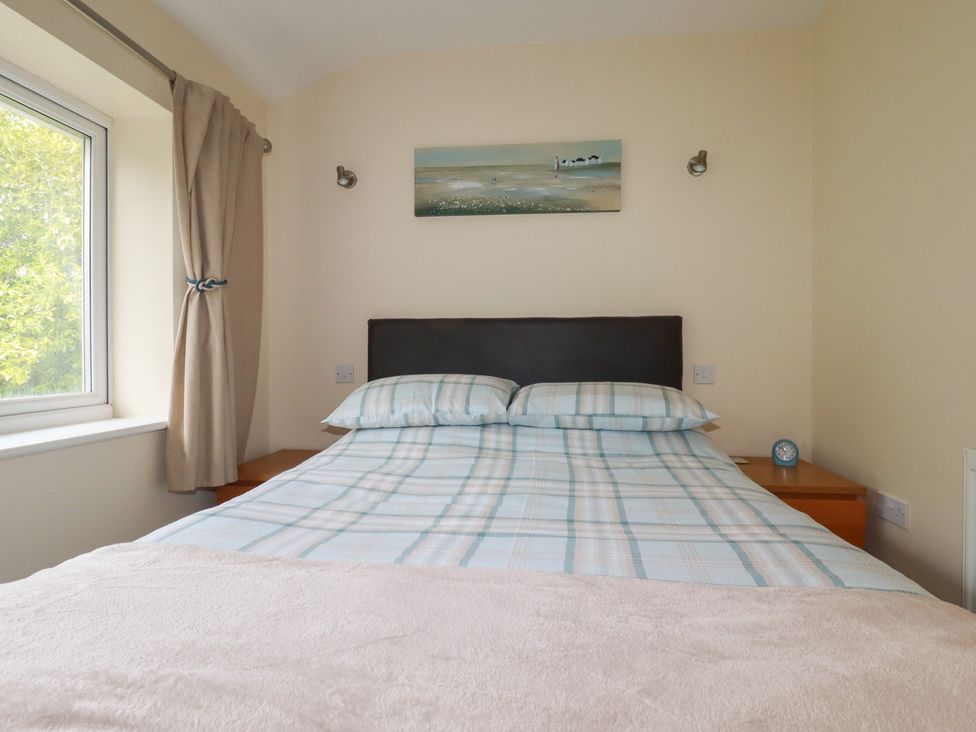 A bedroom with a bed and bedside table at Poolside, Atlantic Reach resort, near St Columb Major