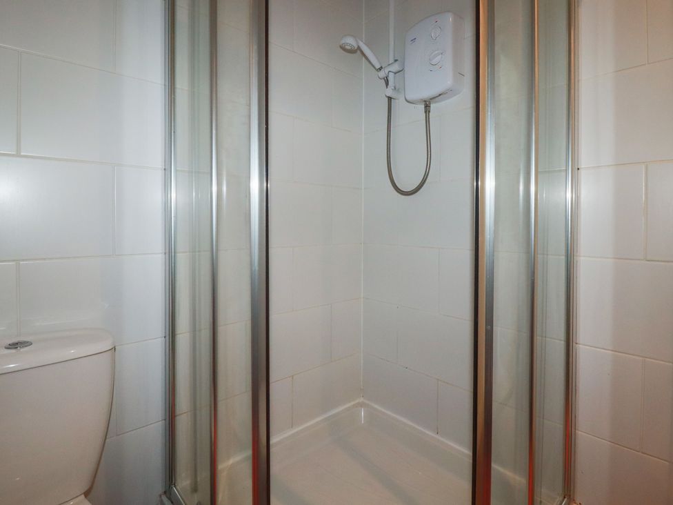 A bathroom with a shower and a toilet at Poolside, Atlantic Reach resort, near St Columb Major
