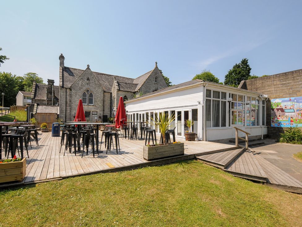 An outdoor area with tables and chairs at Poolside in St Columb Major