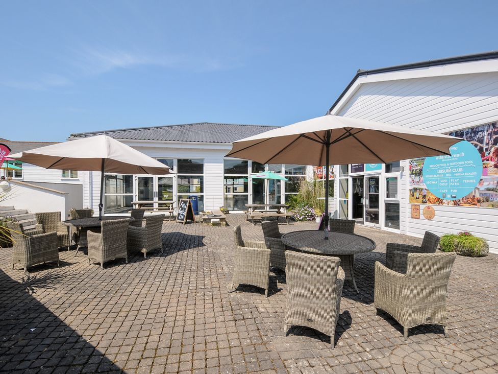 An outdoor area with tables and chairs at Poolside in St Columb Major