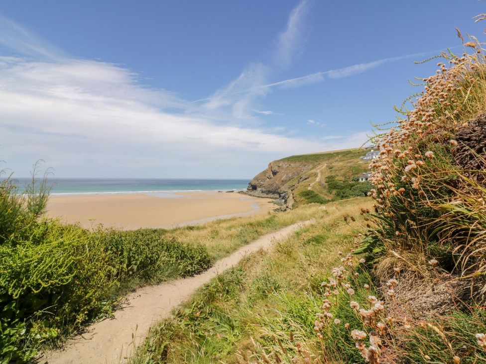 A beach scene with a path and cliffs at Poolside in St Columb Major