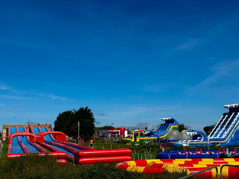 Inflatable slides and play structures at an outdoor event at Poolside 66 Atlantic Reach, Atlantic Reach Resort, Newquay, Cornwall