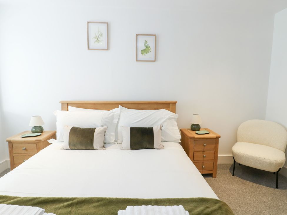 A bedroom with a bed and nightstand at Glynllifon 4 in Marianglas