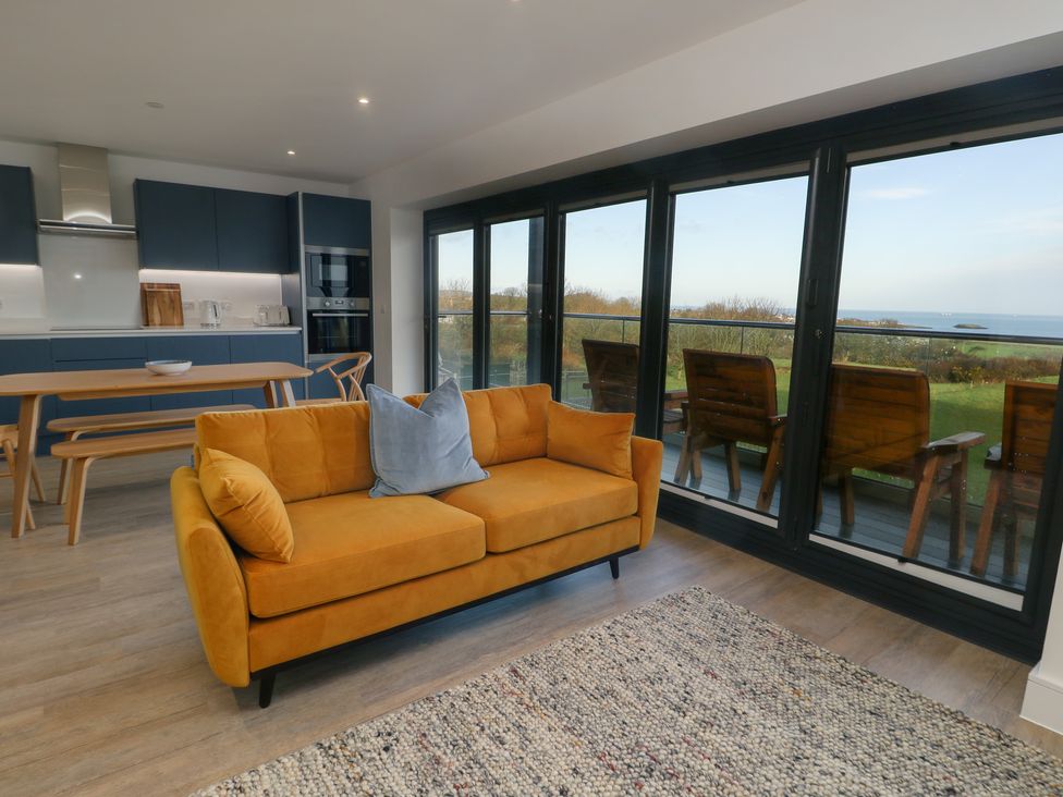 A living room with a sofa and table at Glynllifon 6 in Marianglas