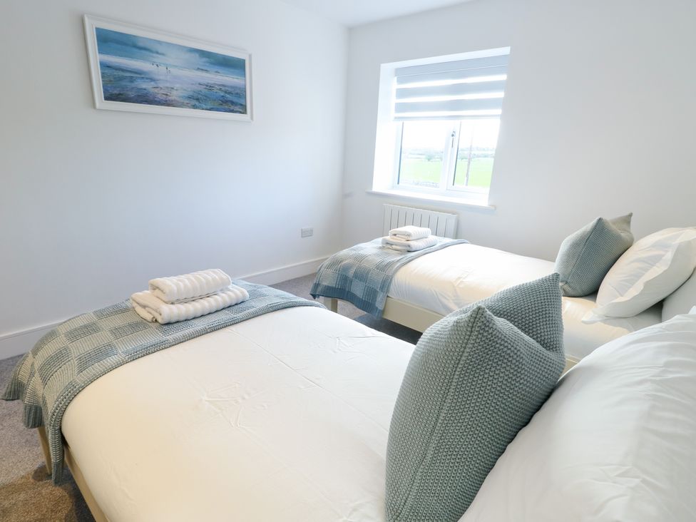 A bedroom with two beds and a window at Glynllifon 6 in Marianglas